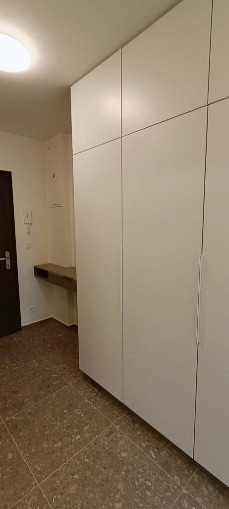 Vysoká bílá vestavěná skříň v předsíni